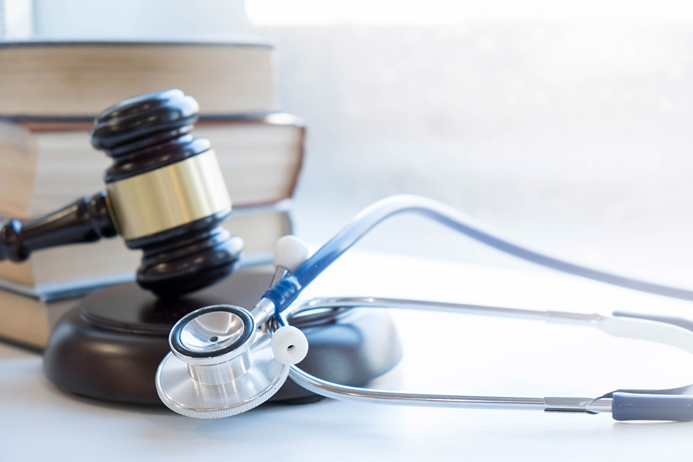 A judge 's gavel and stethoscope on top of a table.