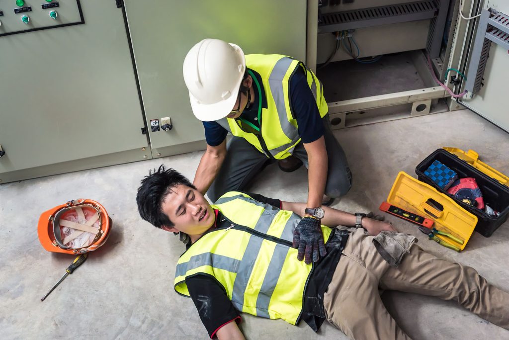 A construction worker is laying on the ground