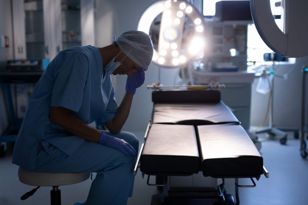 A surgeon sitting in front of a table.